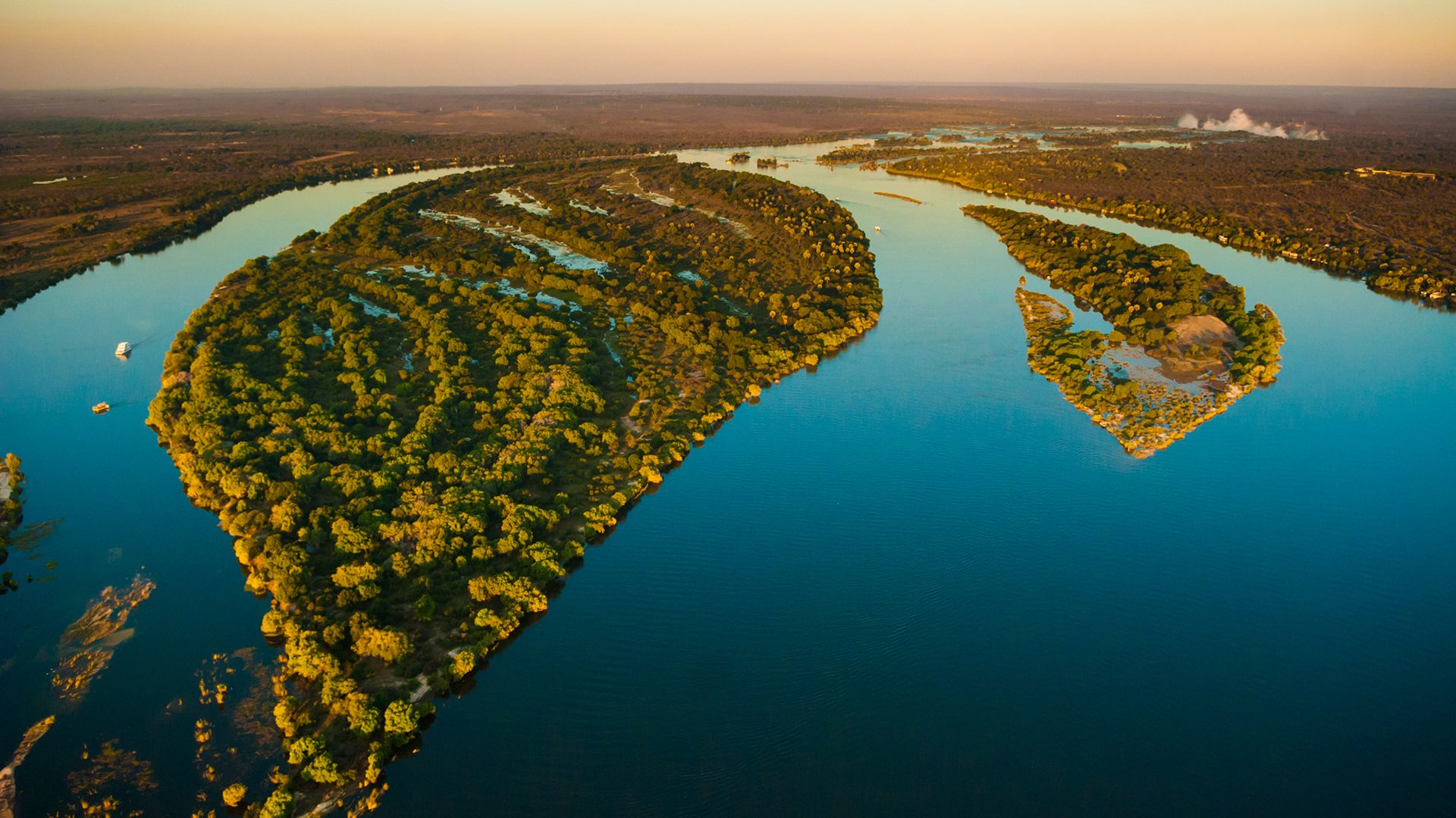 Aerial view of the Zambezi river and Victoria falls with riverboats